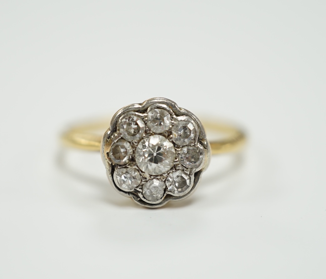 A yellow metal and diamond set flower head cluster ring, size H, gross weight 1.7 grams.
